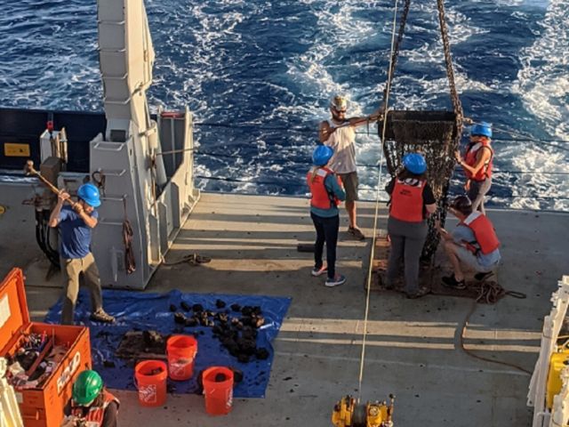 UCSB scientists prepare to dredge more rocks from the seafloor, while breaking up and analyzing samples from a previous dredge.